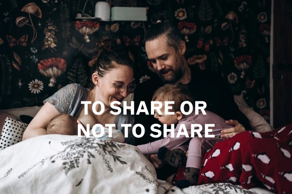 Mallory and Brian in bed in their PJs while Eloise leans over to touch Baby K